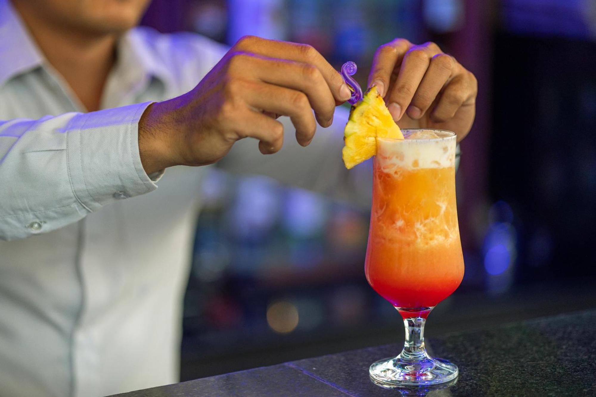Two Seasons Siem Reap Hotel Екстер'єр фото A bartender adding a pineapple wedge to a Hurricane